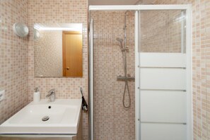 A bathroom with a sink, mirror, shower, and tiled walls. - WELCS ESTUDIO 178 EMP cerca del mar (Empuriabrava)