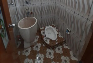 Een badkamer met een toilet en een douchetoilet.