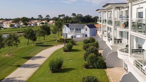 Un hotel moderno con un patio central, piscina y vistas a una zona residencial.