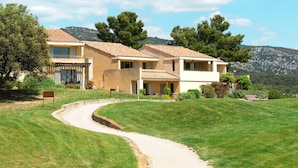 A two-story house with a tiled roof, a paved driveway, and a grassy lawn. - Provence Country Club by Interhome (L'isle sur la Sorgue)