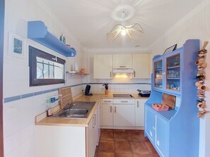 Una cocina compacta con fregadero, estufa y armarios.