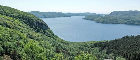 A panoramic view of a lake surrounded by forested hills.