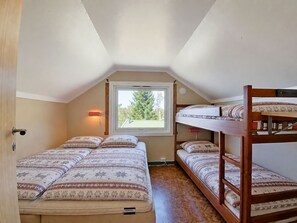 Un dormitorio con literas, una ventana y una lámpara fijada a la pared.