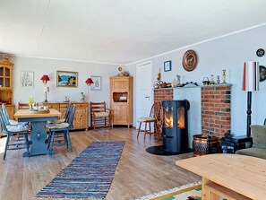 A cozy living room with a fireplace, wooden furniture, and a dining area.