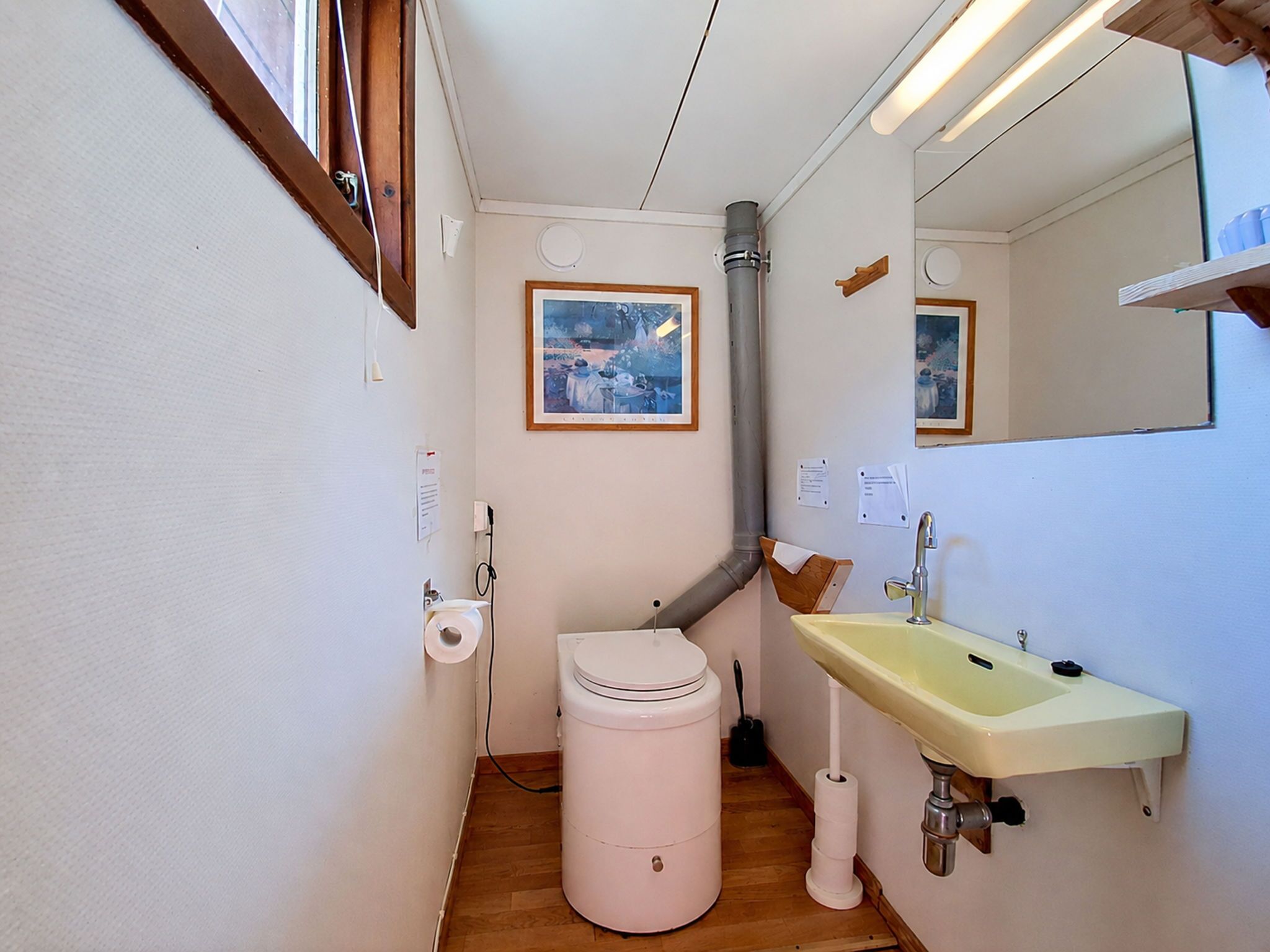 Casa de banho compacta com sanita, lavatório e zona de duche.