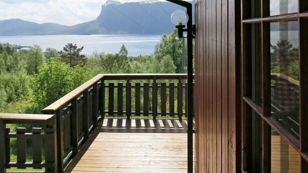 A wooden deck with a view of a lake and mountains. - Fjordperlen by Interhome (Sørbøvåg)