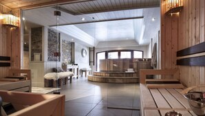 A modern spa with wooden interiors, a stone wall, and a central seating area.