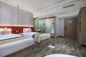 A hotel room with two beds, a bathroom, and a wardrobe.