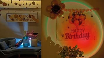 A room with a sofa, a decorative wall, and a birthday-themed decoration.