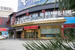 A hotel with a prominent sign, a balcony with red lanterns, and a storefront with signage. - Star Sky Hotel (Pingjiang)