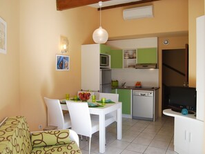 Um espaço compacto com área de refeições, cozinha compacta e TV.
