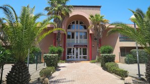 Un edificio con fachada roja, ventanas de arco y un letrero que dice 