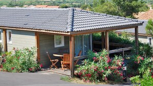 Ein eingeschossiges Haus mit Ziegeldach und einer überdachten Veranda, mit Blick auf eine ländliche Gegend.