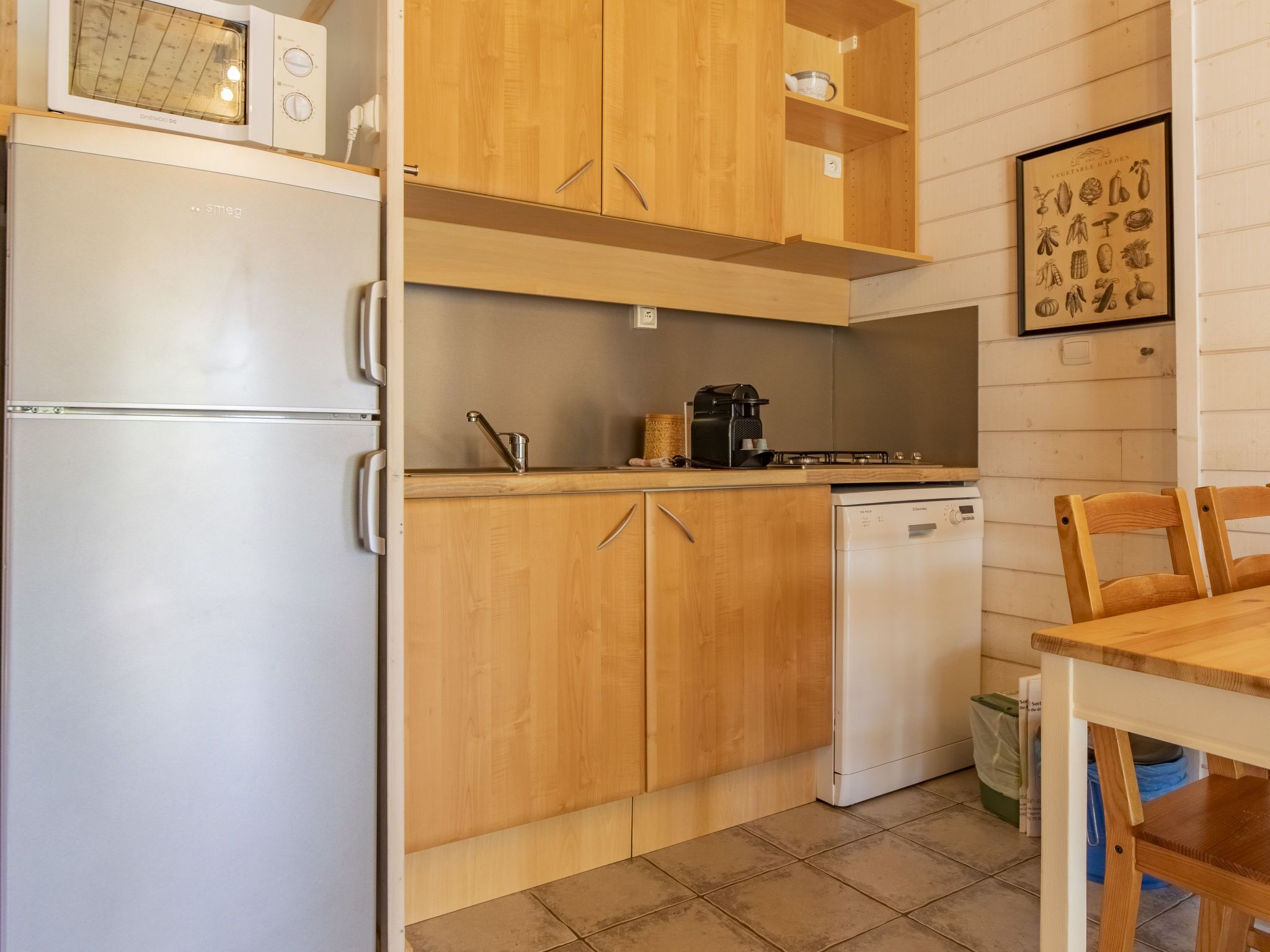 A compact kitchen with wooden cabinets, a built-in microwave, a coffee maker, and a dishwasher.