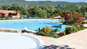 A swimming pool with a wooden cabin and a view of green hills in the background. - Domaine de Sévenier Chêne Blanc by Interhome (Vallon-Pont-d'Arc)