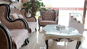 A room with two upholstered armchairs, a glass coffee table, and a potted plant. - Lake Holiday Hotel (Chizhou)