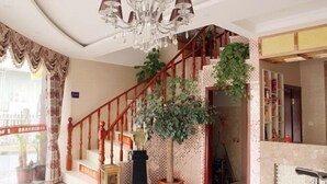 A staircase with a wooden handrail and a potted plant at the top. - Lake Holiday Hotel (Chizhou)