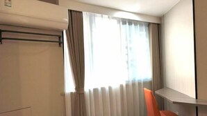 A room with a window, a chair, and a radiator. - Lake Holiday Hotel (Chizhou)