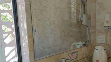 A bathroom with a sink, mirror, and a towel rack.
