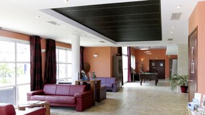 A lobby with a red sofa, a billiards table, and a reception desk. - Les Jardins Renaissance by Interhome (Azay-le-Rideau)
