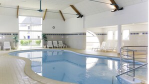 An indoor swimming pool with clear water, surrounded by lounge chairs and a tiled floor. - Les Jardins Renaissance by Interhome (Azay-le-Rideau)