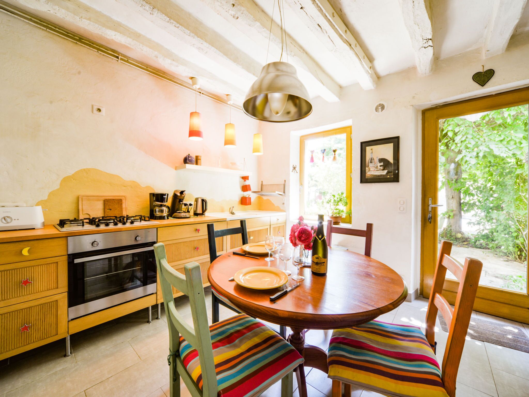 Een gezellige keuken met een houten tafel, stoelen en een hanglamp.