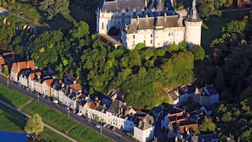 Een luchtbeeld van een historisch kasteel, omringd door een stad met smalle straatjes en een rivier.