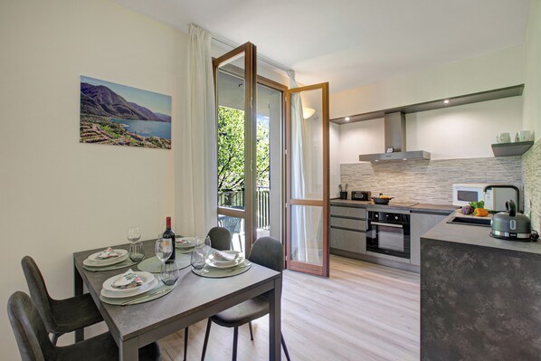 A modern kitchen with a dining area, a view of the outdoors, and a large window.