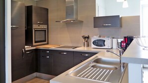 A modern kitchen with stainless steel appliances, a built-in oven, a microwave, and a sink with a modern faucet.