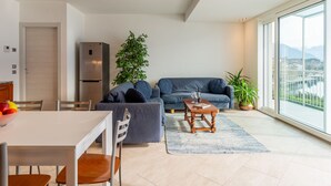 Uma sala de estar moderna com área de jantar, uma janela ampla com vista e geladeira embutida.