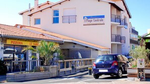 Un edificio con un letrero que indica 'Residence de la Plage Centrale' y una 'Pizzeria Le Napoli' en la planta baja.