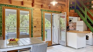 A wooden cabin with a dining area, kitchen, and a staircase. - L'Escouarte by Interhome (Maubuisson)