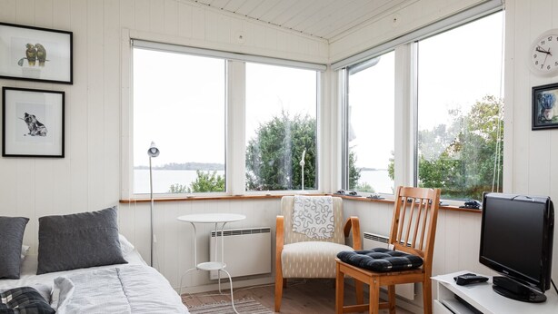 Une chambre confortable avec un lit, une chaise, une petite table et un téléviseur.
