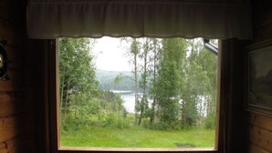 A room with a large window overlooking a lake and forest. - Borrsjön by Interhome (Gräsmark)