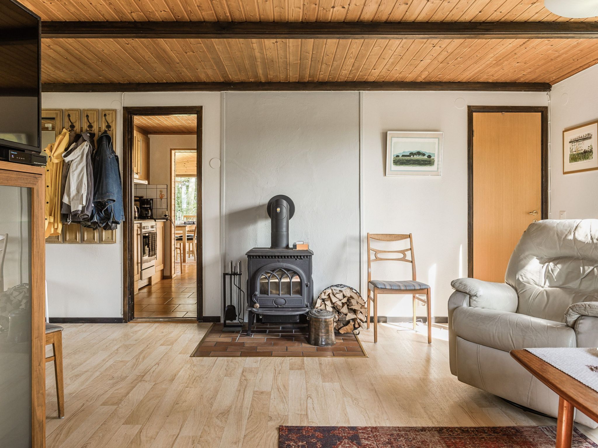 A cozy living room with a wood-burning stove, a sofa, and a chair.