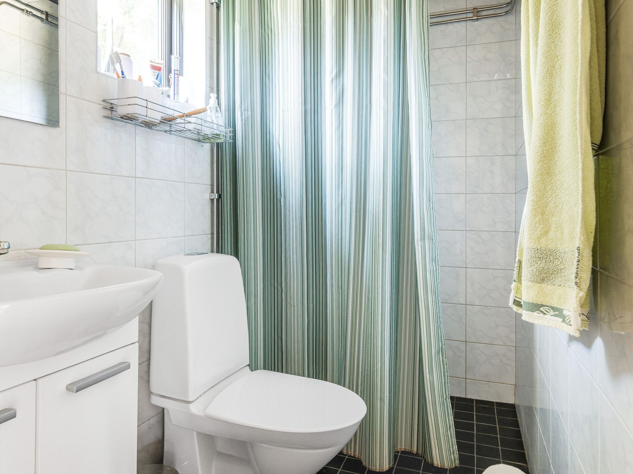 A bathroom with a white toilet, a sink, and a shower curtain.