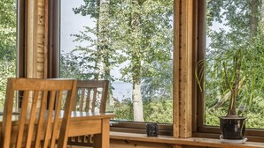 Un intérieur en bois avec une fenêtre donnant sur une forêt et un lac.