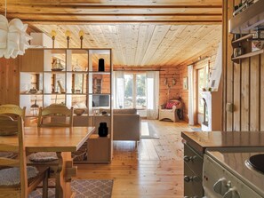 Un interno accogliente con un tavolo da pranzo in legno, sedie, un divano e un angolo cottura.