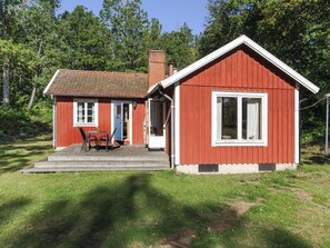 A red wooden house with a porch, a door, and a window. - Ängsjömåla by Interhome (Eringsboda)