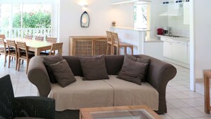 Ein Wohnzimmer mit einer Couch, einem Couchtisch und einem Essbereich mit Stühlen und einem Tisch.