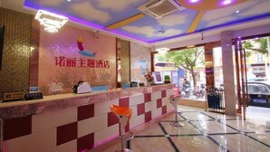 A hotel reception area with a check-in counter, two bar stools, and a decorative wall with a bird motif. - Light Stay·Noli Theme Hotel (Shanghai Fengxian Nanqiao Branch) (Shanghai)
