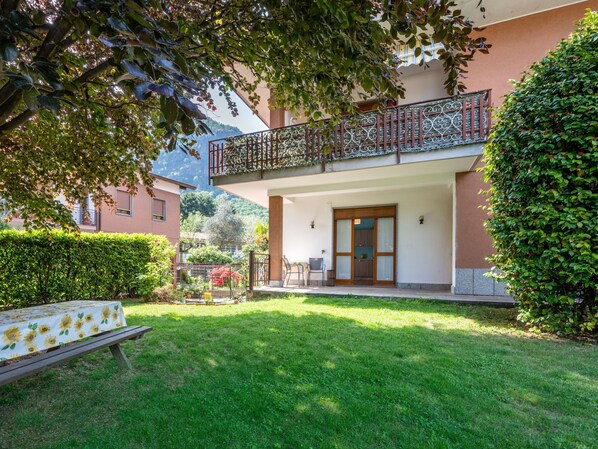 A two-story building with a balcony, a covered entrance, and a well-maintained garden. - Les Maisons della Fattoria by Interhome (Orta San Giulio)