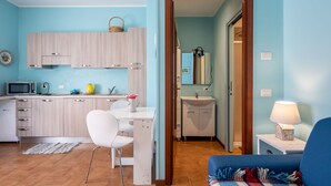 Un espacio habitable compacto con kitchenette, comedor y baño.