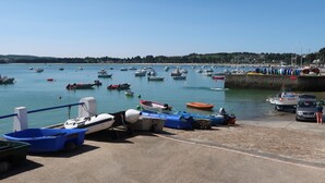 A harbor with various boats docked and a car parked near the shore. - Villa de la Baie by Interhome (Locquirec)