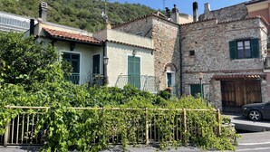 A traditional stone building with a tiled roof, a wooden fence, and a car parked in front. - Casa del Pernambuco (PTL205) by Interhome (Pietra Ligure)