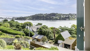 A coastal view with a hillside, a body of water, and a residential area with houses and greenery. - Ti an Aod by Interhome (Plougasnou)