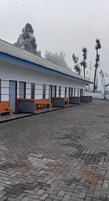 A row of single-room cabins with a tiled floor and a blue and white exterior.