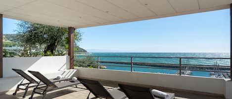 Un balcon avec deux fauteuils et une vue sur la mer.