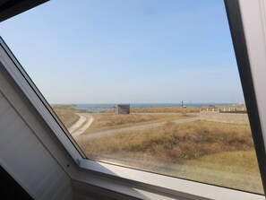 Guests can enjoy a serene view of a tranquil body of water and surrounding landscape from the comfort of their room.