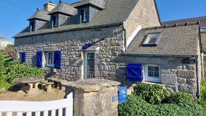 A stone house with a sloped roof, a chimney, and a small balcony. - Kermalo by Interhome (Plouescat)